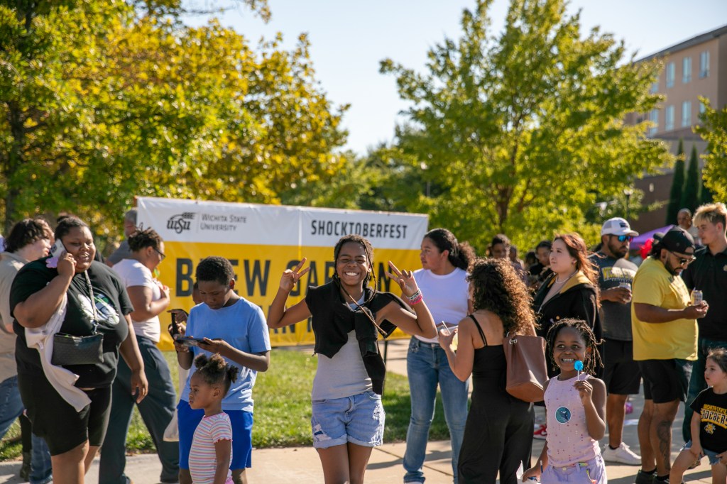Attendees gathered at Shocktoberfest in front of a Wichita State welcome sign during an outdoor campus celebration.